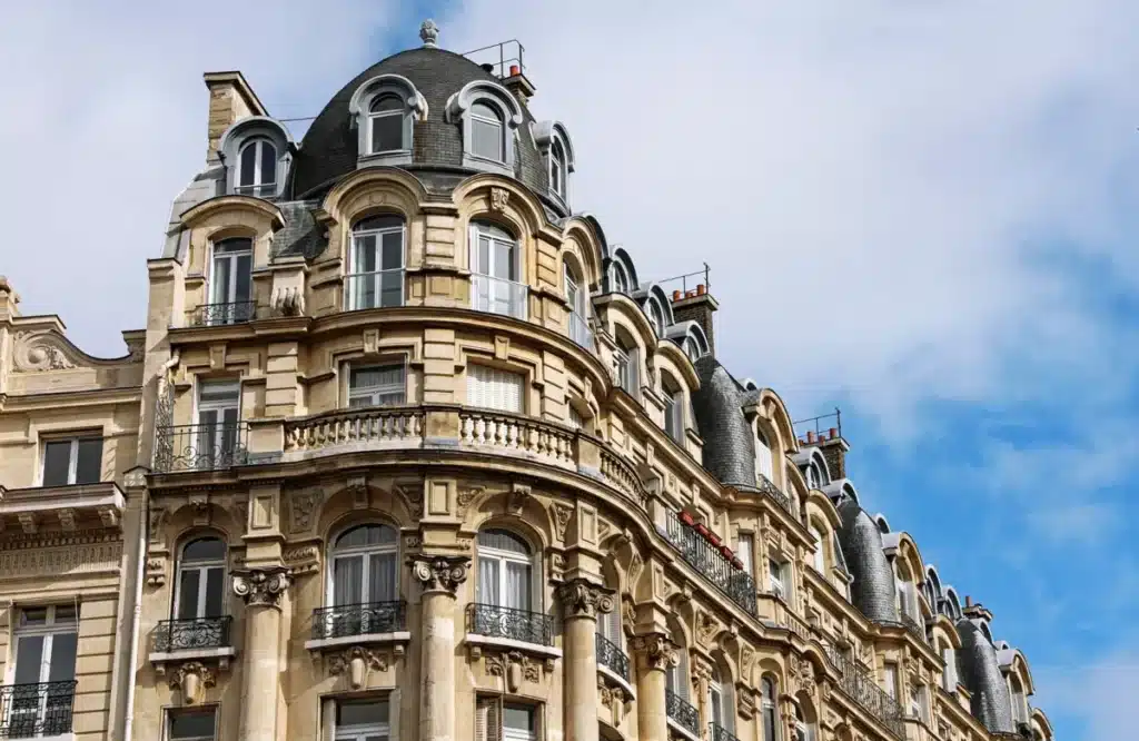Façade d'un immeuble haussmannien élégant avec des détails architecturaux raffinés, idéal pour illustrer des solutions immobilières urbaines.