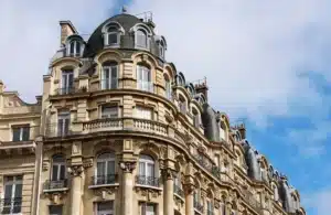 Façade d'un immeuble haussmannien élégant avec des détails architecturaux raffinés, idéal pour illustrer des solutions immobilières urbaines.